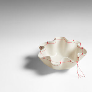 Hand formed porcelain with re-purposed thread and/or textiles.